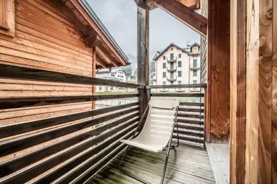 a chair sitting on a balcony looking out a window at Chalet Inari Chamonix - by EMERALD STAY in Chamonix-Mont-Blanc