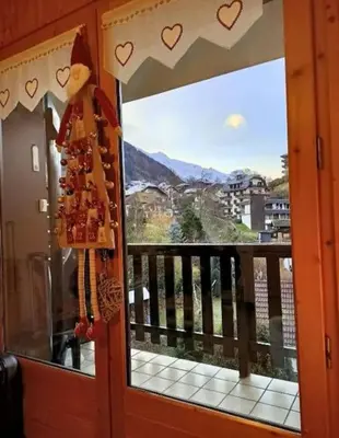 a door to a balcony with a view of the mountains at Studio cabine 4 personnes, votre refuge montagnard in Saint-Gervais-les-Bains