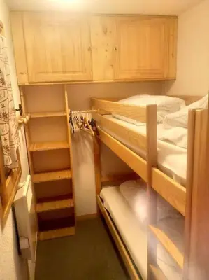 a room with two bunk beds and wooden cabinets at Studio cabine 4 personnes, votre refuge montagnard in Saint-Gervais-les-Bains