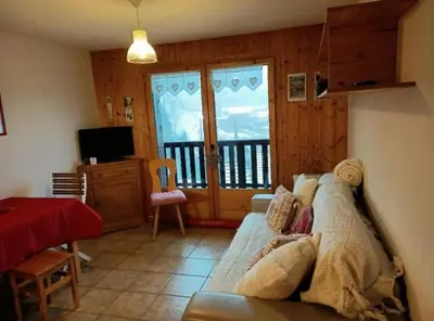 a living room with a couch and a balcony at Studio cabine 4 personnes, votre refuge montagnard in Saint-Gervais-les-Bains