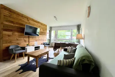 a living room with a couch and a table and a television at Le Refuge Diorama in Saint-Gervais-les-Bains
