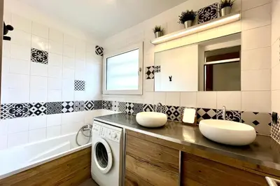 a bathroom with a washing machine and a sink at Le Refuge Diorama in Saint-Gervais-les-Bains