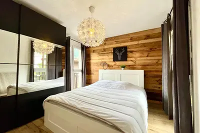 a bedroom with a large bed and a chandelier at Le Refuge Diorama in Saint-Gervais-les-Bains