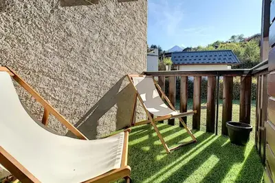 a balcony with a hammock and a chair on the grass at Le Refuge Diorama in Saint-Gervais-les-Bains