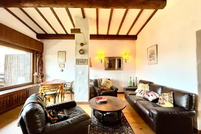 a living room with leather furniture and a table at L’Héritage Régence in Megève