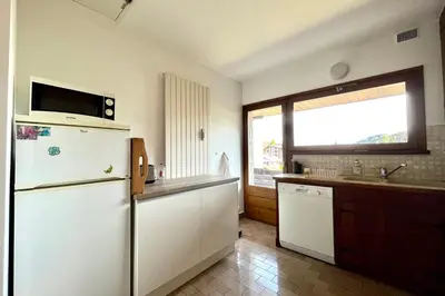 a kitchen with a white refrigerator and a sink at L’Héritage Régence in Megève