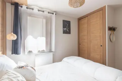 a bedroom with a white bed and a window at L'Altima Megève - Eclat des Veriaz in Megève