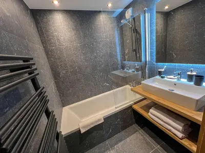 a bathroom with a sink and a bath tub at L'Altima Megève - Eclat des Veriaz in Megève