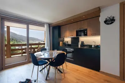 a kitchen and dining room with a table and chairs at L'Altima Megève - Eclat des Veriaz in Megève