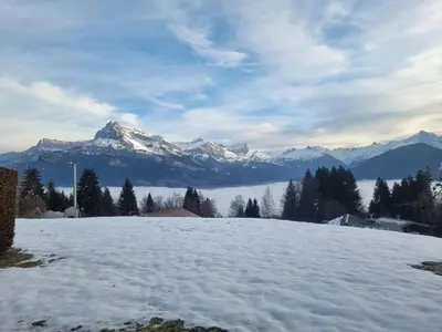 a snow covered field with mountains in the background at Charmant 3 pièces avec jardin, parking et proximité ski bus à 900m du village de Combloux - FR-1-560-121 in Combloux
