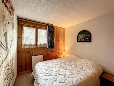 a bedroom with a white bed and a window at Charmant 3 pièces avec jardin, parking et proximité ski bus à 900m du village de Combloux - FR-1-560-121 in Combloux