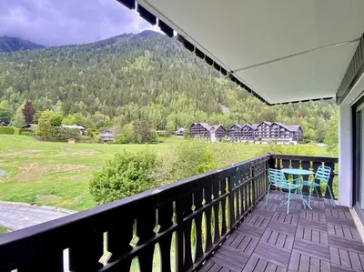 a balcony with a table and chairs and a mountain at Pied des pistes/Hyper centre/Balcon/Parking in Chamonix-Mont-Blanc