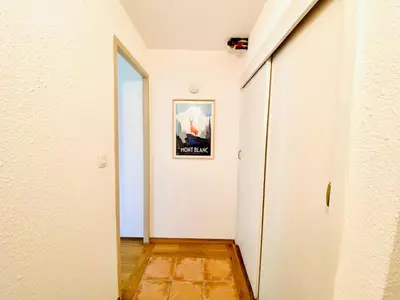 a hallway with a white wall and a picture on the wall at Pied des pistes/Hyper centre/Balcon/Parking in Chamonix-Mont-Blanc