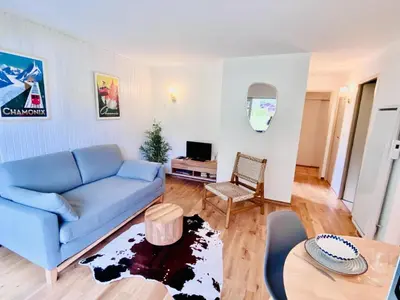 a living room with a blue couch and a table at Pied des pistes/Hyper centre/Balcon/Parking in Chamonix-Mont-Blanc