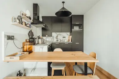 a kitchen with a wooden table and chairs at Le Cocon Blanc - Appartement « cosy & chic » in Megève