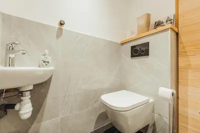 a bathroom with a toilet and a sink at Le Cocon Blanc - Appartement « cosy & chic » in Megève
