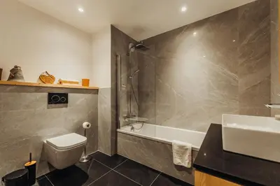a bathroom with a tub and a toilet and a sink at Le Cocon Blanc - Appartement « cosy & chic » in Megève