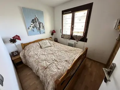a bedroom with a bed and a window at Résidence Le Royal - Charmant T3 dans le centre de Combloux MAE-2721 in Combloux