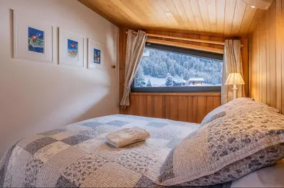 a bed in a room with a wooden ceiling at Beautiful apartment with superb view of Mont Blanc in Chamonix-Mont-Blanc