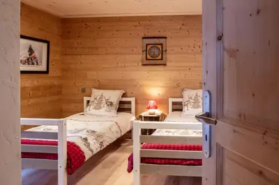 a bedroom with two beds in a log cabin at Charmant appartement dans chalet, coeur de Megève in Megève