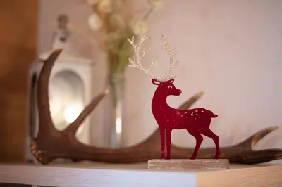 a small red figurine of a deer on a table at Charmant appartement dans chalet, coeur de Megève in Megève