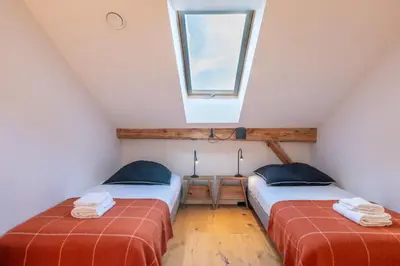 two beds in a attic room with a window at Pretty loft with view of Mont Blanc & glacier in Chamonix-Mont-Blanc