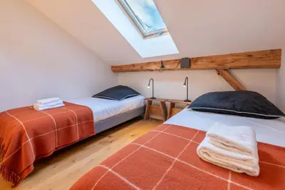 two beds in a attic bedroom with a window at Pretty loft with view of Mont Blanc & glacier in Chamonix-Mont-Blanc