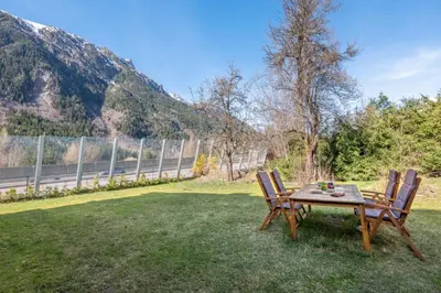 a picnic table and two chairs on the grass at Pretty loft with view of Mont Blanc & glacier in Chamonix-Mont-Blanc