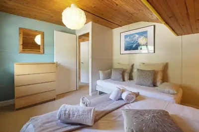 a room with two beds and a dresser in it at Chalet La Cordée, 160m2, 4 chambres, sauna in Saint-Gervais-les-Bains