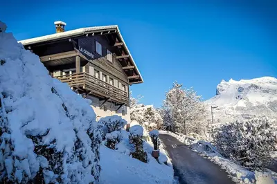 a building covered in snow next to a road at Chalet La Cordée, 160m2, 4 chambres, sauna in Saint-Gervais-les-Bains