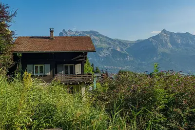 a house on a hill with mountains in the background at Chalet La Cordée, 160m2, 4 chambres, sauna in Saint-Gervais-les-Bains