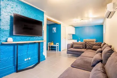 a living room with a couch and a tv on a blue wall at Chalet La Cordée, 160m2, 4 chambres, sauna in Saint-Gervais-les-Bains