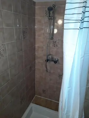 a bathroom with a shower with a tub and a shower curtain at Le chalet des neiges 3 est au calme situé à 5 mn à pied du centre juste à côté du terrain de foot est composé canapé convertible et 3 lits supperposés parking privé sur place et arrêt navette gratuite à 30 m in Les Carroz d'Araches