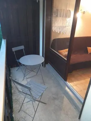 a table and chairs in a room with a bed at Le chalet des neiges 3 est au calme situé à 5 mn à pied du centre juste à côté du terrain de foot est composé canapé convertible et 3 lits supperposés parking privé sur place et arrêt navette gratuite à 30 m in Les Carroz d'Araches