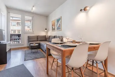 a living room with a dining room table and a couch at Le Balcon du Brevent - Central - Vue montagne in Chamonix-Mont-Blanc