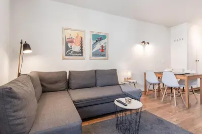 a living room with a couch and a table at Le Balcon du Brevent - Central - Vue montagne in Chamonix-Mont-Blanc