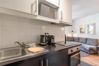 a kitchen with a sink and a couch at Le Balcon du Brevent - Central - Vue montagne in Chamonix-Mont-Blanc