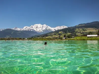 a person in the water with mountains in the background at Studio mezzanine au centre de Combloux avec parking - FR-1-560-123 in Combloux