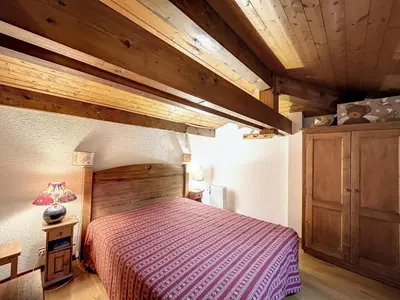a bedroom with a bed in a room with wooden ceilings at Studio mezzanine au centre de Combloux avec parking - FR-1-560-123 in Combloux