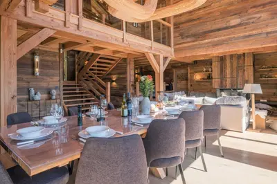 a dining room with a long wooden table and chairs at Chalet 14 personnes I Luxe I Piscine & Sauna I Salle cinéma I Le Chalet Club in Combloux