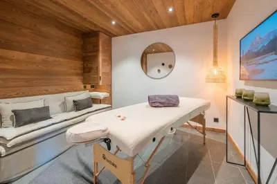 a room with a table and a bed at Chalet 14 personnes I Luxe I Piscine & Sauna I Salle cinéma I Le Chalet Club in Combloux