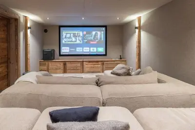 a living room with couches and a flat screen tv at Chalet 14 personnes I Luxe I Piscine & Sauna I Salle cinéma I Le Chalet Club in Combloux