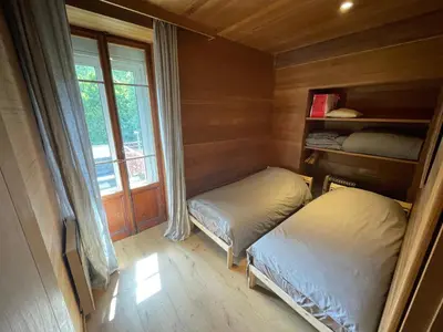 a small room with two beds and a window at 10 Bel-Alp in Chamonix-Mont-Blanc