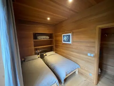 two beds in a room with wooden walls at 10 Bel-Alp in Chamonix-Mont-Blanc