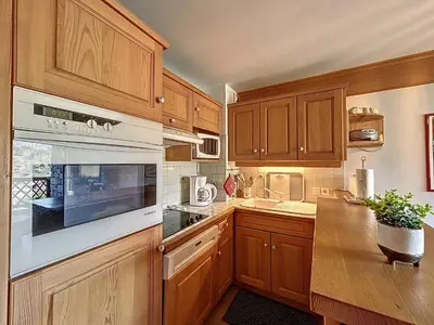a kitchen with wooden cabinets and white appliances at Appartement 2 chambres avec parking et wifi à Combloux - FR-1-560-124 in Combloux