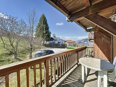a porch with a table and a chair on a deck at Appartement 2 chambres avec parking et wifi à Combloux - FR-1-560-124 in Combloux