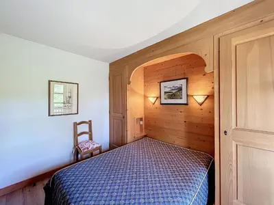 a bedroom with a bed and a wooden wall at Appartement 2 chambres avec parking et wifi à Combloux - FR-1-560-124 in Combloux