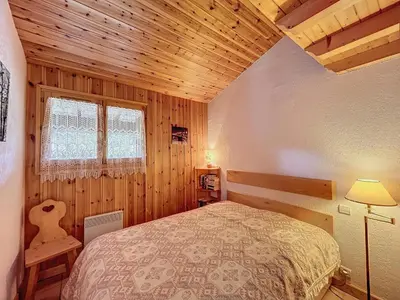a bedroom with a bed and a wooden ceiling at Appartement avec garage proches ski bus à Combloux - FR-1-560-126 in Combloux