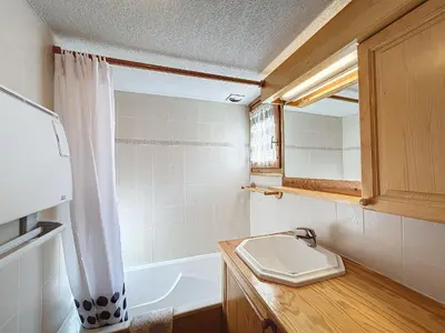 a bathroom with a sink and a tub and a mirror at Appartement avec garage proches ski bus à Combloux - FR-1-560-126 in Combloux