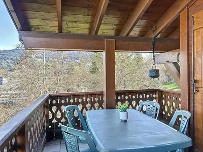 a blue table and chairs on a wooden deck at Appartement avec garage proches ski bus à Combloux - FR-1-560-126 in Combloux